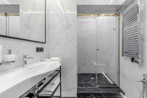 a white bathroom with a shower and a sink at Equides club in Lesniki