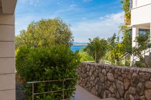 a stone wall with a view of the ocean at Apartment Golden Sun in Dramalj +24 photos