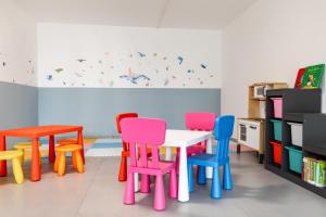 a classroom with colorful chairs and a table at Hotel Alexander in San Mauro a Mare