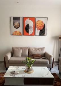 a living room with a couch and four pictures on the wall at Wepick Homes in Kigali