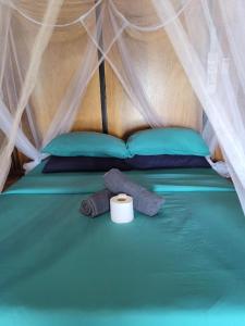 a bed in a tent with a roll at The Station Tioman in Tioman Island