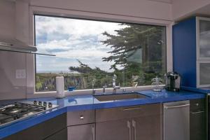 a kitchen with a sink and a large window at Bodega Bay Magical Ocean Front w/Amazing View! in Bodega Bay