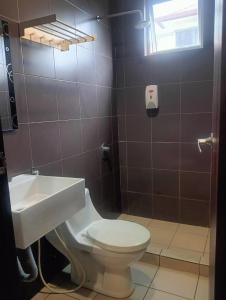 a bathroom with a toilet and a sink at M BOUTIQUE INN (PERMYJAYA) in Miri