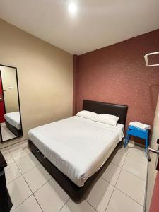 a bedroom with a bed and a blue stool in it at M BOUTIQUE INN (PERMYJAYA) in Miri
