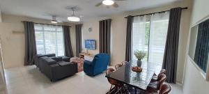 a living room with a table and a couch and chairs at Teratak Teratai Homestay- Corner in Semenyih