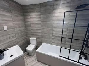 City View Apartment في ديربي: حمام مع حوض ومرحاض ومغسلة