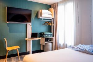 - une chambre avec un lit, un bureau et une chaise dans l'établissement ibis styles Paris Montmartre Batignolles, à Paris