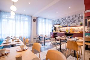 a restaurant with tables and chairs and a kitchen at ibis styles Paris Montmartre Batignolles in Paris