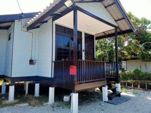 a tiny house with a porch and awning at Teratak Damai STC in Kuala Terengganu