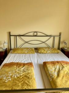 a bedroom with a bed with gold sheets and pillows at Burgblick Pünderich in Pünderich