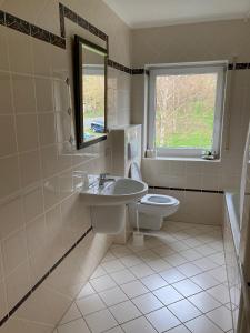 a bathroom with a sink and a toilet and a window at Burgblick Pünderich in Pünderich