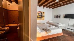 a bedroom with a bed and a bathroom with a television at Casa Viola in Bergamo
