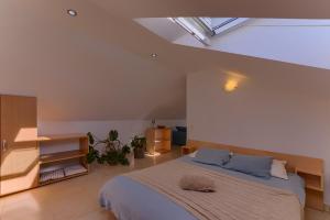 a bedroom with a large bed and a skylight at Guest House Dijana in Korčula +37 photos
