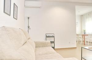 Una sala de estar blanca con un sofá blanco y una mesa. en Apartamento Goya, en Conil de la Frontera