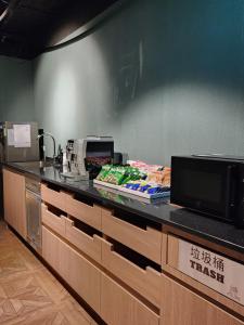 a kitchen with a counter top with a microwave at Fun Stay Inn Ximen in Taipei