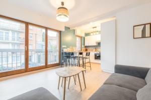 a living room with a couch and a table at Lille Vauban: apartment with parking in Lille