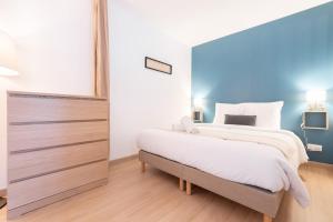 a bedroom with a large bed and a dresser at Lille Vauban: apartment with parking in Lille