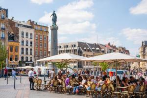 a group of people sitting at tables in a city at Lille Vauban: apartment with parking in Lille