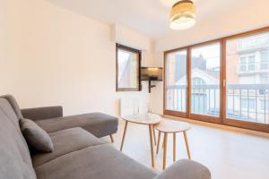 ein Wohnzimmer mit einem Sofa und einem Tisch in der Unterkunft Lille Vauban: apartment with parking in Lille