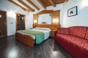 マロスコにあるHotel Bel Soggiornoのベッドルーム(ベッド1台、ソファ付)