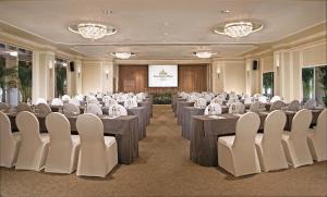 une salle de conférence avec des tables, des chaises et un écran dans l'établissement Goodwood Park Hotel, à Singapour