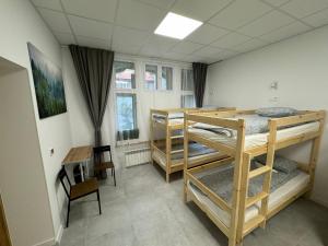 a room with three bunk beds and a desk at Green Hostel Katowice 24h - Parking in Katowice