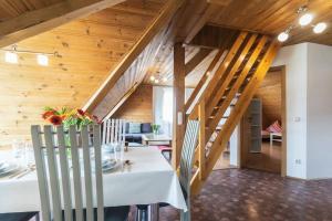 a dining room with a white table and wooden stairs at Apart Nordgrat - Buxacher Straße 23 + Motorradvermietung in Memmingen