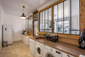 a laundry room with a washer and dryer and windows at L'escapade Vendéenne - Grand jardin 4 chambres in Vix