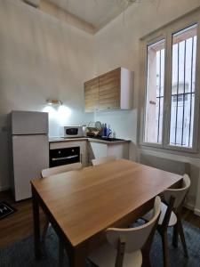 kuchnia z drewnianym stołem, stołem i krzesłami w obiekcie Massalia Apartement, Le Panier w Marsylii