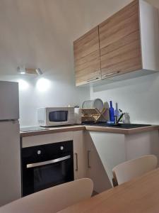 eine kleine Küche mit einer Mikrowelle und einem Tisch in der Unterkunft Massalia Apartement, Le Panier in Marseille