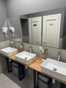 dois lavatórios numa casa de banho pública com dois espelhos em Green Hostel Katowice 24h - Parking em Katowice