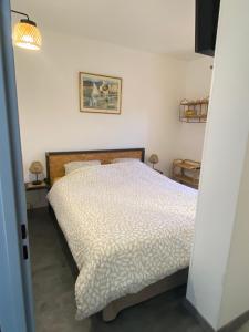 1 dormitorio con 1 cama con edredón blanco en F2 à Collioure avec piscine et tennis, en Collioure