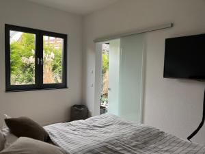 a bedroom with a bed and a flat screen tv at Modernes Tiny Appartement in Lage in Lage