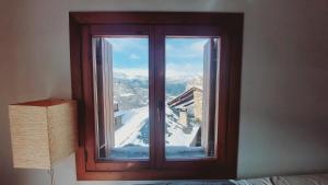una ventana con vistas a una montaña nevada en Apartament Rural Burg, en Burg