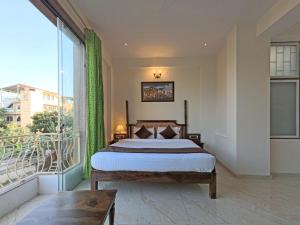 um quarto com uma cama e uma grande janela em Hotel Dera Pichola em Udaipur