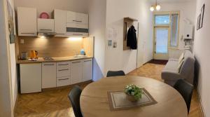 cocina y sala de estar con mesa. en Apartmán Kaiser, en Praga