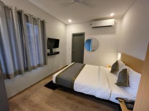 pokój hotelowy z łóżkiem i telewizorem w obiekcie CITYLIGHTS TOWNHOUSE w mieście Allahabad