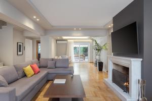 a living room with a couch and a fireplace at Athenian Grand Riviera Villa in Athens