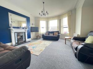 uma sala de estar com dois sofás e uma lareira em Bon-Ami em Lowestoft