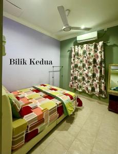 a bedroom with a bed and a sign on the wall at Bangli Homestay in Huma