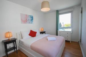 um quarto com uma cama com 2 candeeiros e uma janela em Apartment in residence with balcony and parking em Lille