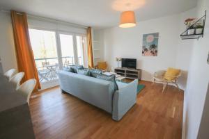uma sala de estar com um sofá e uma televisão em Apartment in residence with balcony and parking em Lille