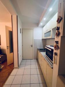 una pequeña cocina con armarios blancos y una puerta en Apartment Babin do, en Budva
