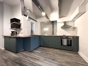 哥特堡的住宿－Penthouse In Vasastaden，厨房配有绿色橱柜和台面