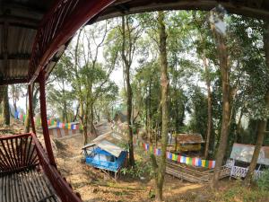 Kurseong的住宿－Sunnyside Campstay，享有带帐篷和树木的游乐场的景致