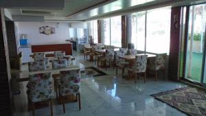 una sala da pranzo con tavoli, sedie e finestre di TOROS OTEL DİDİM a Didim
