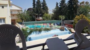 vista sulla piscina con due sedie di TOROS OTEL DİDİM a Didim