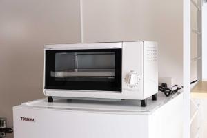 a microwave sitting on top of a white refrigerator at Lino下伊福 in Okayama