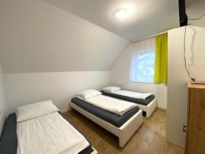 Cette chambre comprend 2 lits et une fenêtre. dans l'établissement Noclegi ul. Lwowska, à Mielec