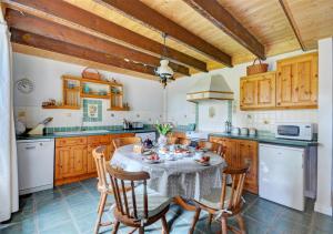 a kitchen with a table and chairs in a kitchen at Manor Cottage in Redruth